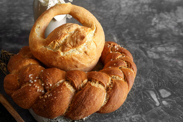 Kalach - traditional Lenten handmade bread on a village table close-up with assortment of handmade bread illuminated by natural light from a window