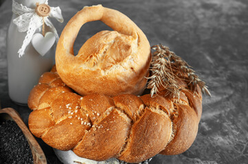 Kalach - traditional Lenten handmade bread on a village table close-up with assortment of handmade bread illuminated by natural light from a window