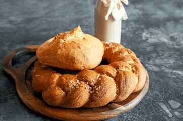 Kalach - traditional Lenten handmade bread on a village table close-up with assortment of handmade bread illuminated by natural light from a window