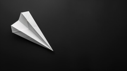 White paper airplane on dark background