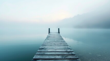 Fototapeta premium Serene morning on a foggy lake with a minimalist wooden pier