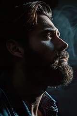 Portrait of serious beard man in low key light side view