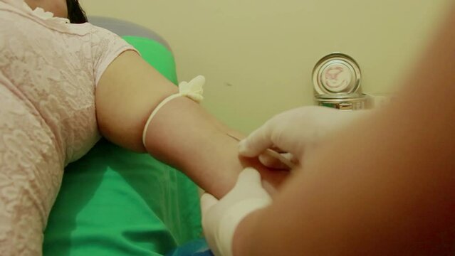 Manos de mujer cogiendo delicadamente una inyeccion  para prueba de sangre