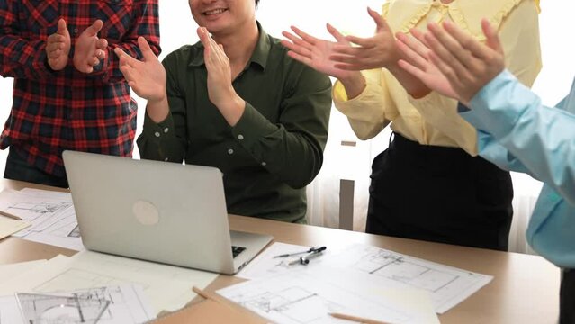 Architect and safety engineer celebrate success design building blueprint project on laptop with architectural document and measurement tool scatter around at modern office. Closeup. Delineation.