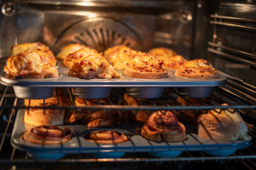 Savory muffins and pastries baking in an oven, the warmth of the kitchen highlighting the comfort...