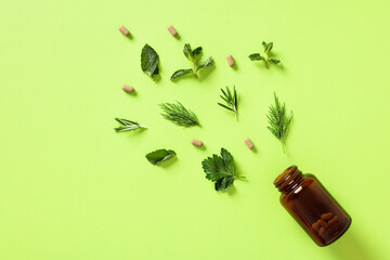 Dietary supplements pills with plant leaves on green background. Concept of healthy lifestyle,...
