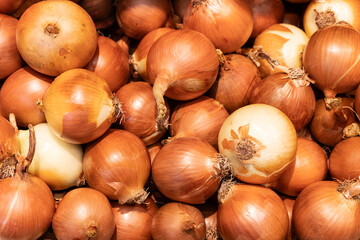 top view lot of fresh big yellow and brown onions with peel at the grocery