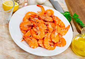 Crispy fried shrimps served with lemon and parsley on white plate. Catalan dish Llagosti