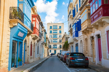 Cozy street and traditional colorful wooden balconies in Sliema, Malta