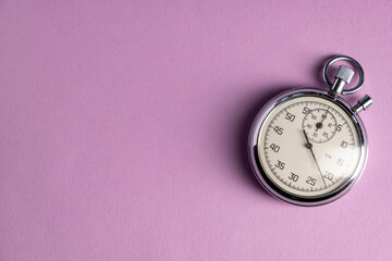 Old clock on a lilac background. Stopwatch in work.