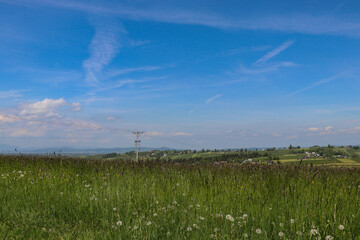 A beautiful panorama of vast Polish meadows against the background of mountains in the Lesser Poland Voivodeship.