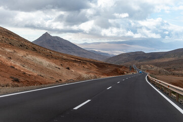 Mountain road on colourful remote basal hills and mountains of Massif of Betancuria, Fuerteventura, Canary islands, Spain