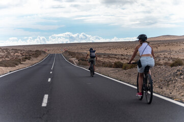 Fototapeta premium Mountain road on colourful remote basal hills and mountains of Massif of Betancuria, Fuerteventura, Canary islands, Spain