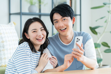 スマホを見る若い仲良しの若い夫婦