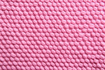 Fototapeta premium Detailed view of soft pink knitting texture, ideal for chic fashion backgrounds and creative projects.