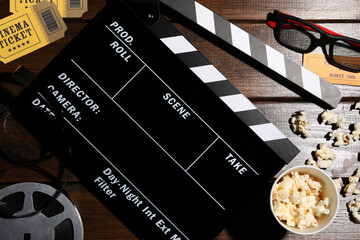 Flat lay composition with clapperboard and popcorn on wooden table