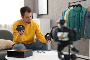 Fashion blogger showing wristwatches while recording video at home