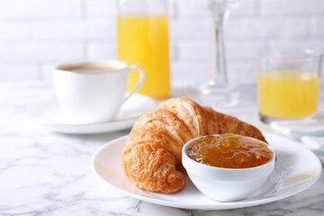 Tasty breakfast. Fresh croissant and jam on white marble table