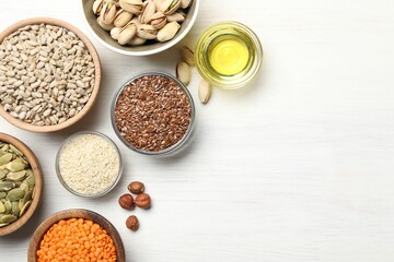 Different products high in vegetable fats on white wooden table, flat lay. Space for text