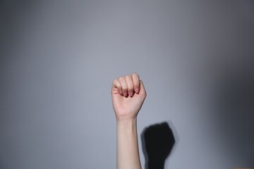 SOS gesture. Woman showing signal for help on grey background, closeup