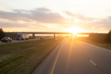 Peaceful Sunset View on Highway with Vehicles Driving Under Overpass