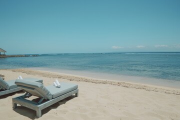 Fototapeta premium A pair of chairs summer tropical beach lapis ocean shore white sand vacation sunbathing island nature holiday clear sky weather coast seaside paradise maldives bali exotic sunny carribean