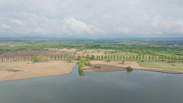Aerial view of the Radolfzeller Aach, which flows into western Lake Constance surrounded by a belt of reeds, behind it the Raolfzeller Aachried, on the horizon the Hegauberge, district of Constance