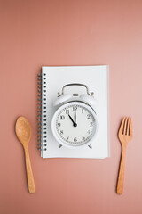 The alarm clock with spoon and fork for intermittent fasting and diet.
