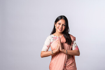 Indian pretty young woman posing with namaskara, namaste or welcome posture