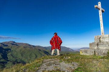 man with Peruvian poncho greeting the hills, Peruvian shaman looking at the horizon