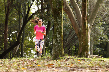 Young woman running in forest
