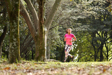 Obraz premium Young woman running in forest 