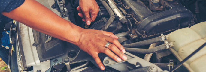 Banner Close up Mechanic man hands repairing car auto repair shop. Banner Man hands fixing...