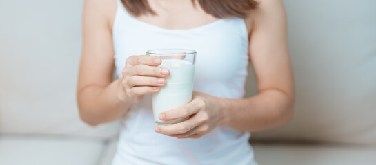 Milk drink and Daily Routine concept. Young woman Drinking milk with high calcium and nutrition at...