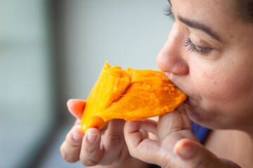 Woman enjoying a juicy mango for these hot summer days.