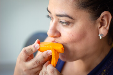 Woman enjoying a juicy mango for these hot summer days.