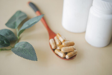 herbal medicine capsule on a wooden spoon 