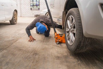 Mechanic elevating a car with manual lift