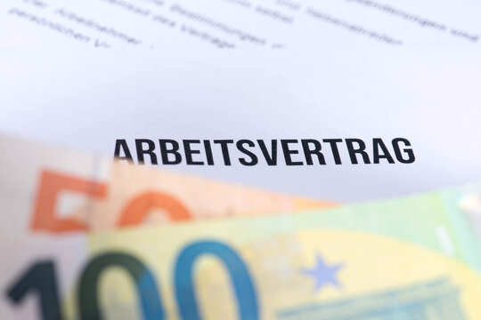 Euro Geldscheine und ein Arbeitsvertrag