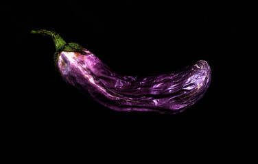 Withered eggplant on black background