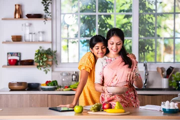 Foto auf Acrylglas Indian mother daughter cooking in kitchen © StockImageFactory