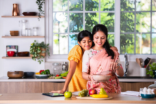 Fototapeta Indian mother daughter cooking in kitchen