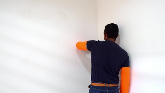 Male Painter Cleaning Wall Before Painting - Close Up