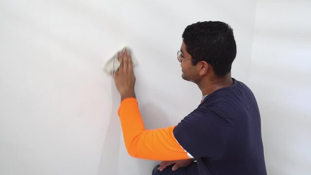 A Man Cleaning the Interior Wall of the House Prior to Painting it - Static Shot