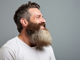 Obraz premium A man with a beard and a white shirt is smiling