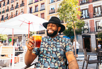 Black man having a drink in a bar terrace