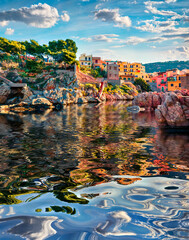 Old colorful building of Sant' Elia village reflected in the calm waters of Mediterranean sea....