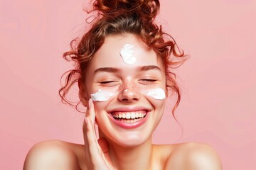 Young Woman Smiling With Skincare Cream on Face Against Pink Background