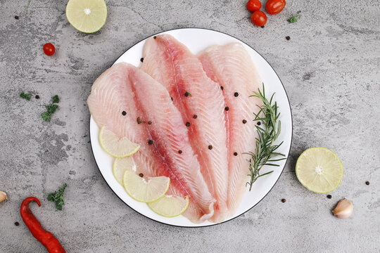 Fresh Dory Fish Fillet with Condiments on Gray Marble Background 