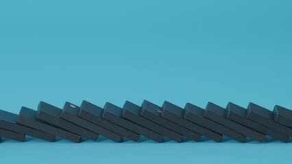 Domino effect, row of domino falling down on blue background.